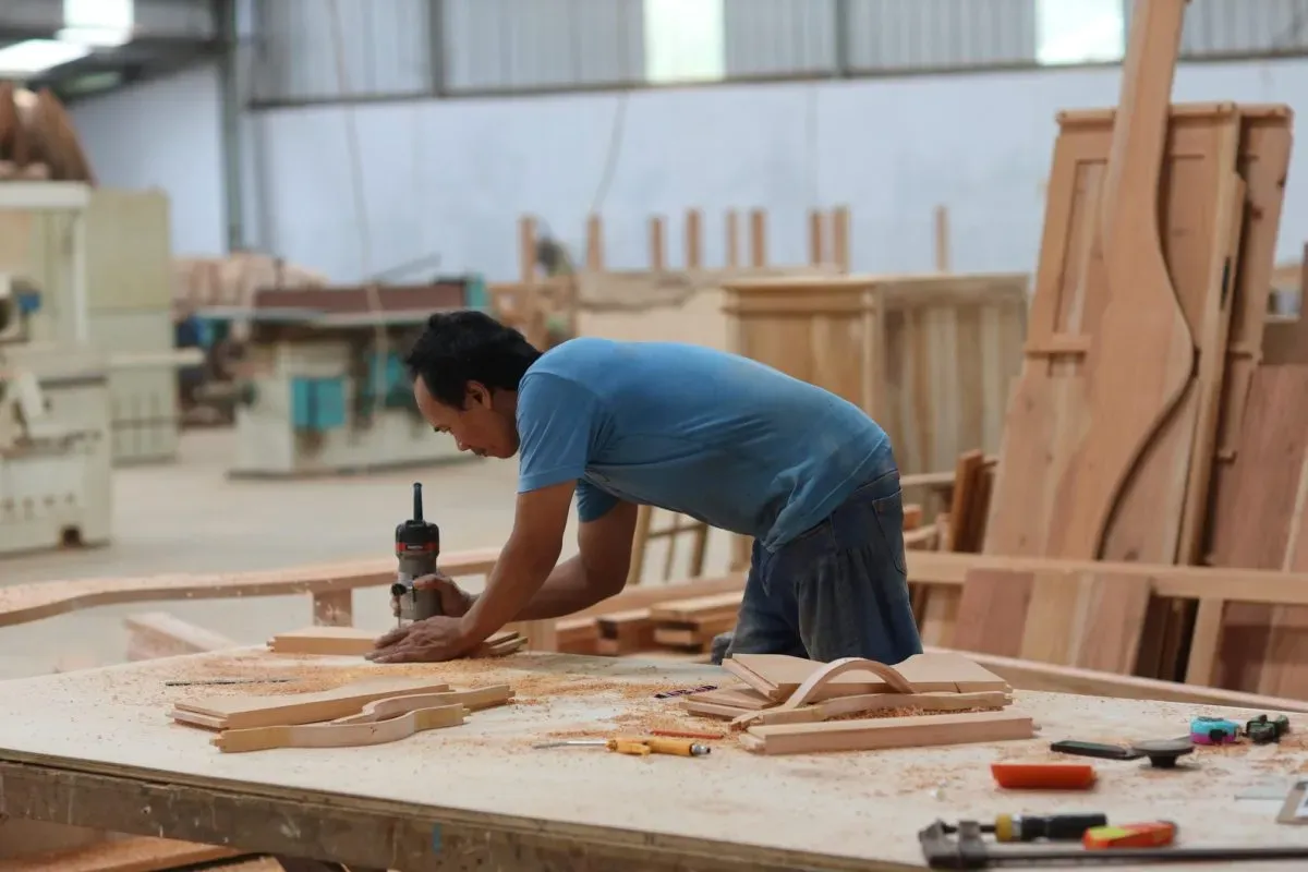 Carpenter sanding wood in a woodworking workshop