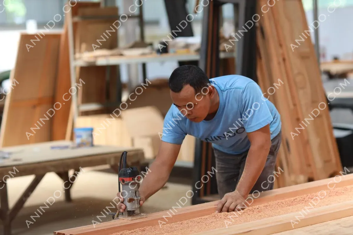 Carpenter sanding wooden board in workshop