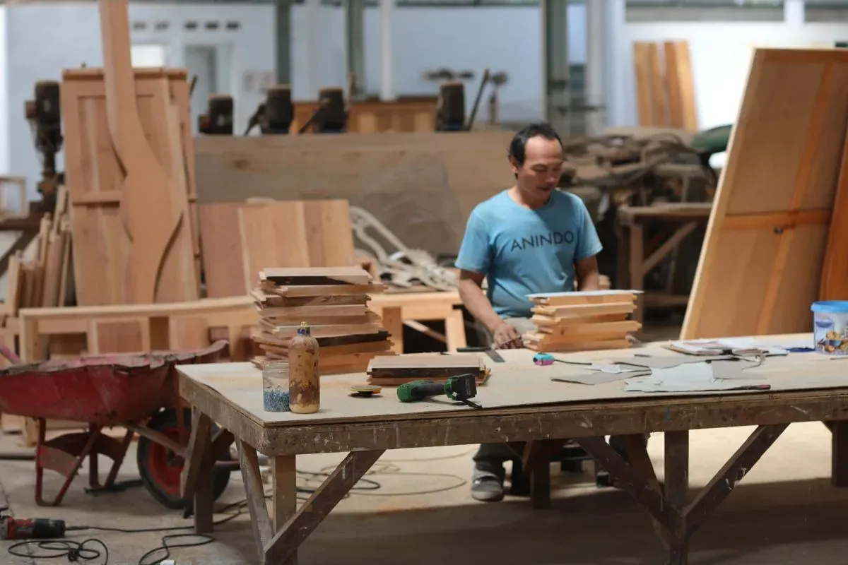 Carpenter working with wooden boards in workshop