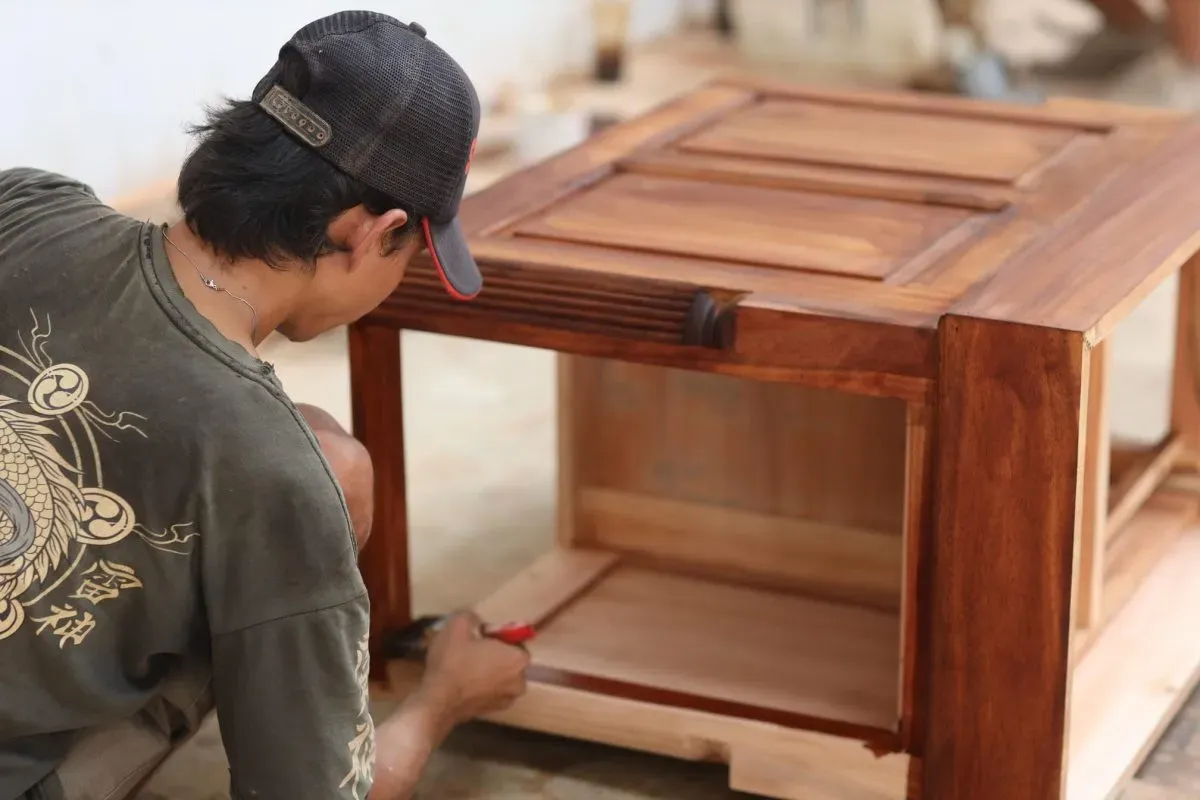 Person woodworking and finishing wooden furniture piece