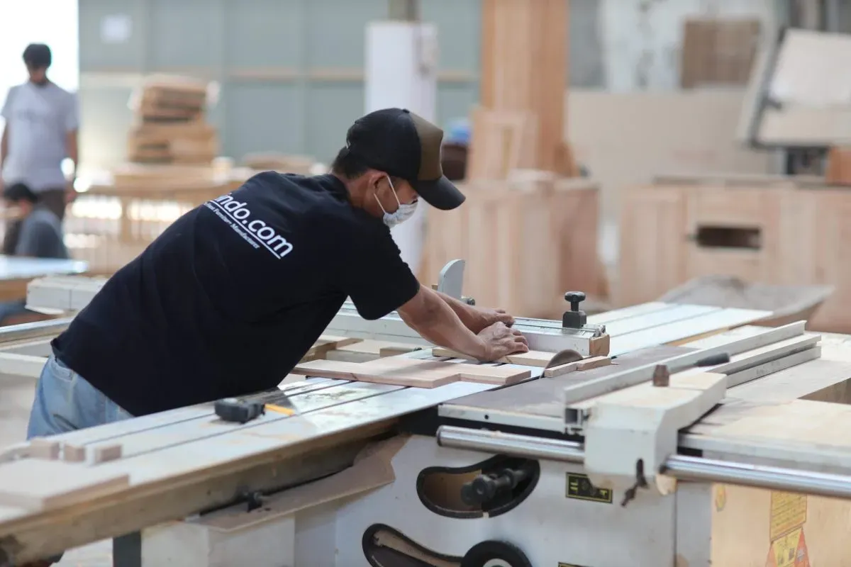 Carpenter cutting wood in workshop