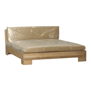 Stylish, modern bed with protective plastic covering.