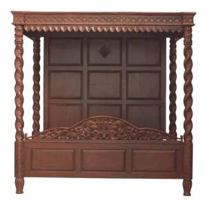 Intricately carved wooden bed with a canopy.