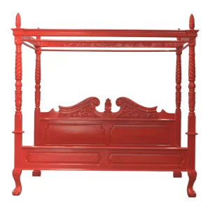 Elegant red canopy bed with ornate detailing.