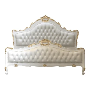Elegant white and gold tufted bed headboard.
