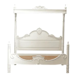 Elegant white four-poster bed with decorative details.