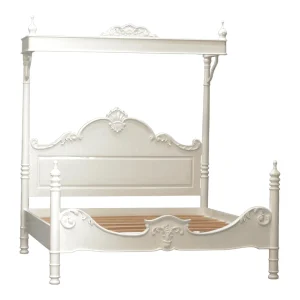 Elegant white four-poster bed with intricate detailing.