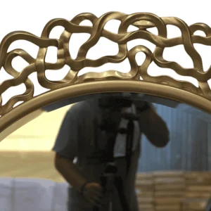 Decorative gold mirror with artistic frame design.