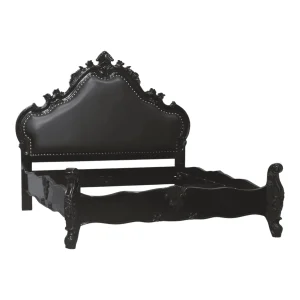 Elegant black antique bed frame with intricate design.