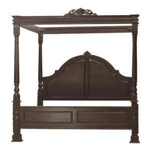 Elegant wooden four-poster bed with decorative details.