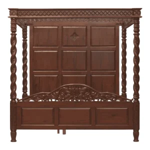 Ornate wooden four-poster bed with detailed carvings.